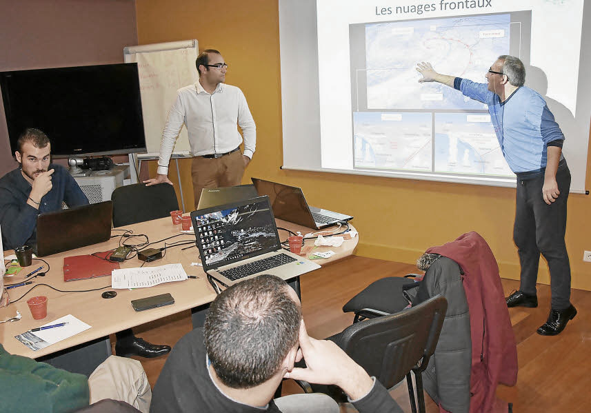 Réunion des adhérents lors d'une assemblée générale (circa 2015). Jérôme Dréano, debout, expose au tableau une formation sur les nuages devant les adhérents assis.